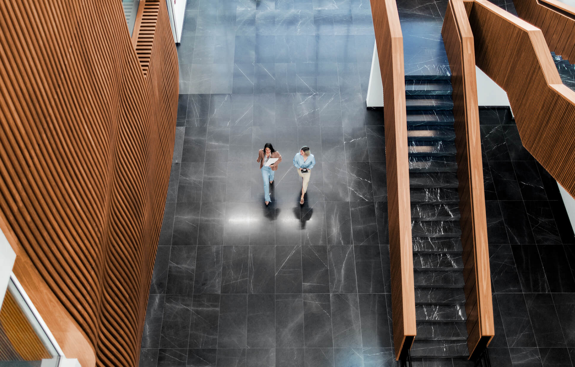 Two women walking down the hall of an office